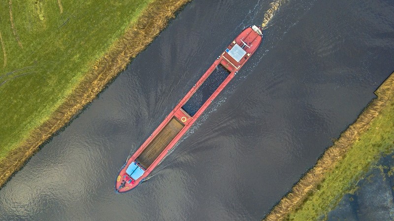 Top down view on inland cargo ship in dutch canal