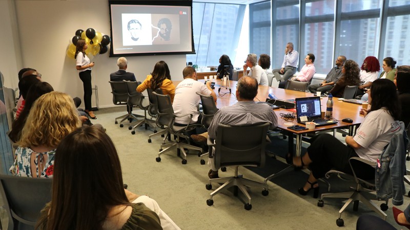 Pessoas reunidas em um espaço corporativo assistindo à uma palestra