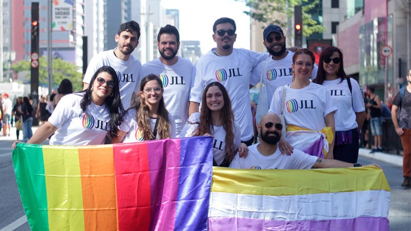 Pessoas com a bandeira do Orgulho LGBTI+