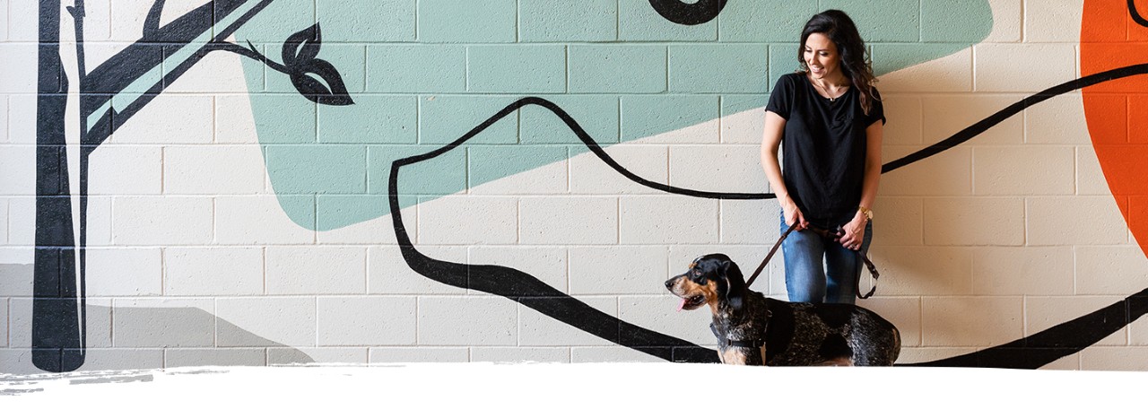 A woman enjoys a mural with her dog in Atlanta's Ponce City Market